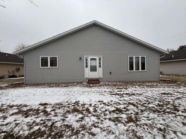 snow covered house with central AC unit