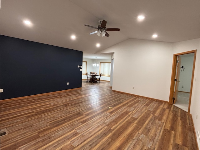 unfurnished living room with dark hardwood / wood-style floors, lofted ceiling, and ceiling fan with notable chandelier