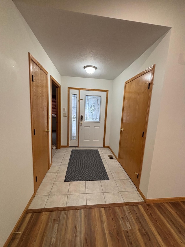 doorway featuring a textured ceiling and light wood-type flooring