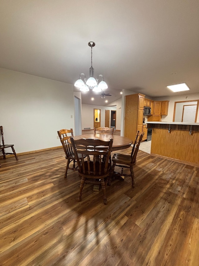 dining room with dark hardwood / wood-style flooring and a notable chandelier