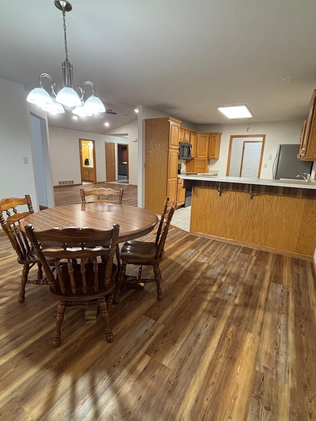 dining area featuring wood-type flooring and a notable chandelier