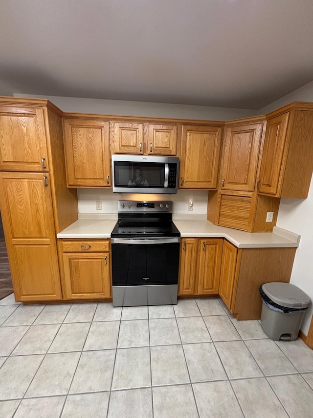 kitchen with appliances with stainless steel finishes and light tile patterned floors