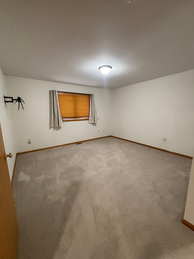 carpeted spare room featuring a textured ceiling