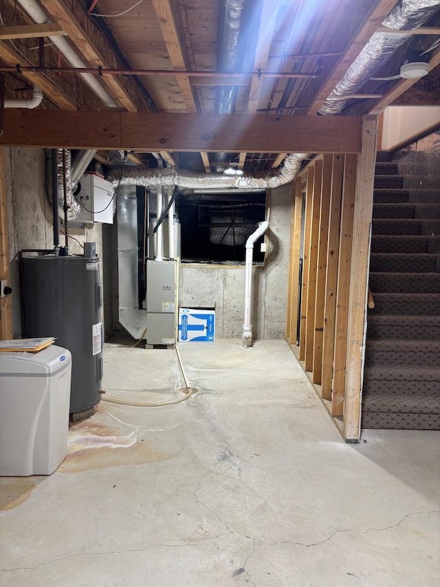 basement featuring heating unit and electric water heater