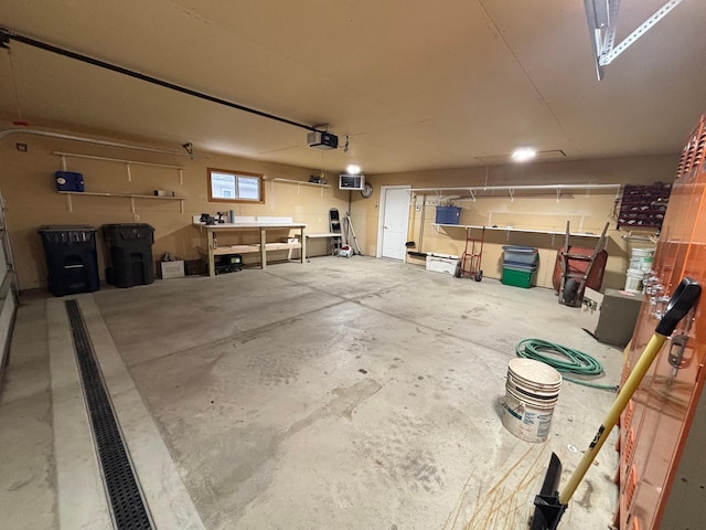 garage with a workshop area and a garage door opener