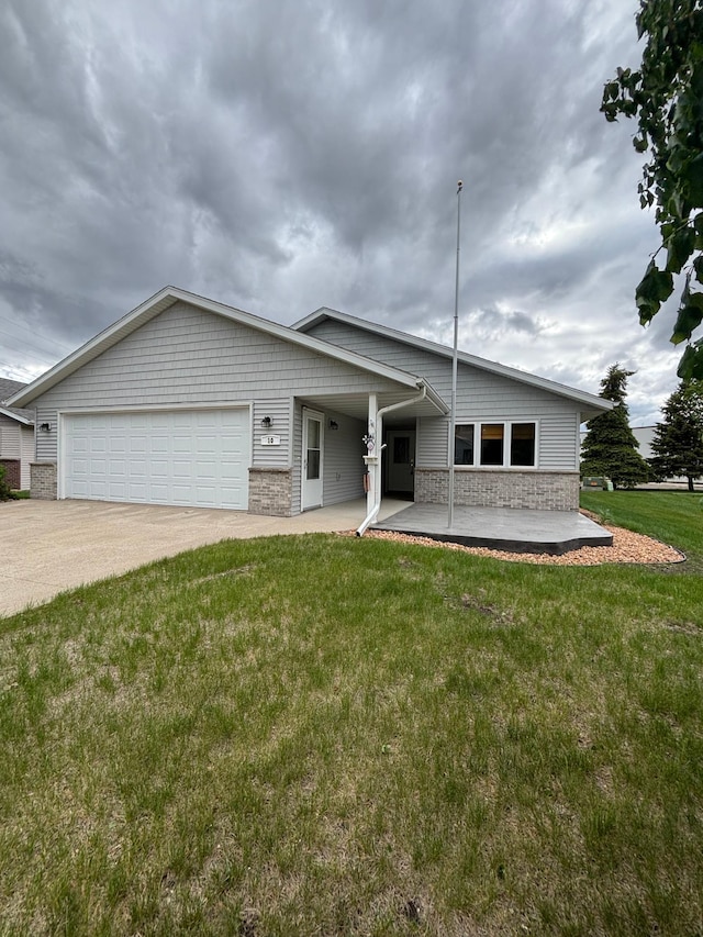 10 Townhouse Rd, Morris, MN 56267 - view of front of home featuring an attached garage, concrete driveway, and a front yard