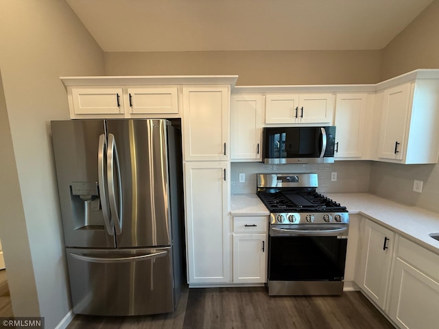 kitchen with tasteful backsplash, dark hardwood / wood-style flooring, white cabinets, and appliances with stainless steel finishes