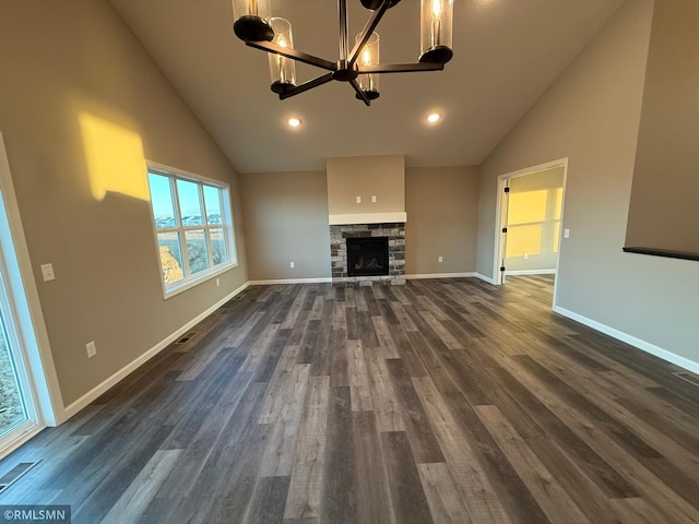 unfurnished living room with a fireplace, dark wood-type flooring, high vaulted ceiling, and a notable chandelier