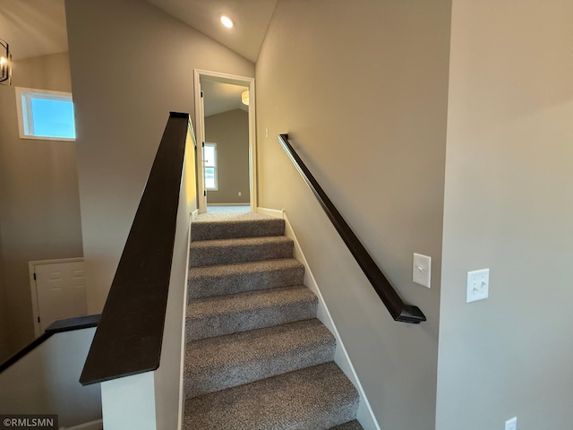 staircase featuring a wealth of natural light, carpet, and lofted ceiling