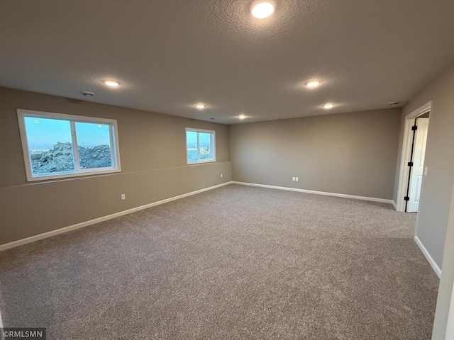 carpeted empty room with a textured ceiling