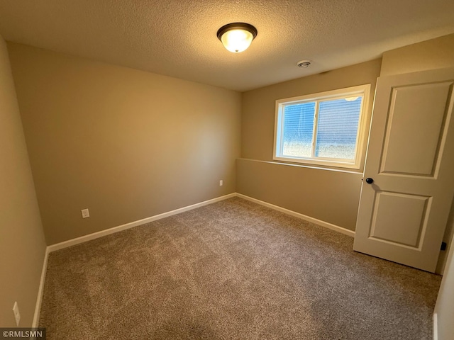 unfurnished room featuring carpet flooring and a textured ceiling