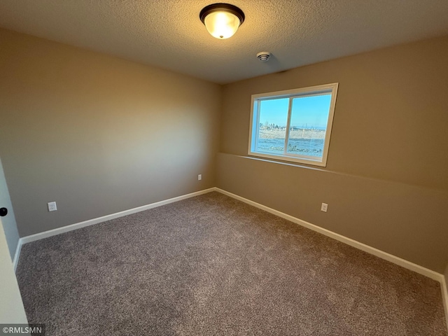 carpeted spare room with a textured ceiling