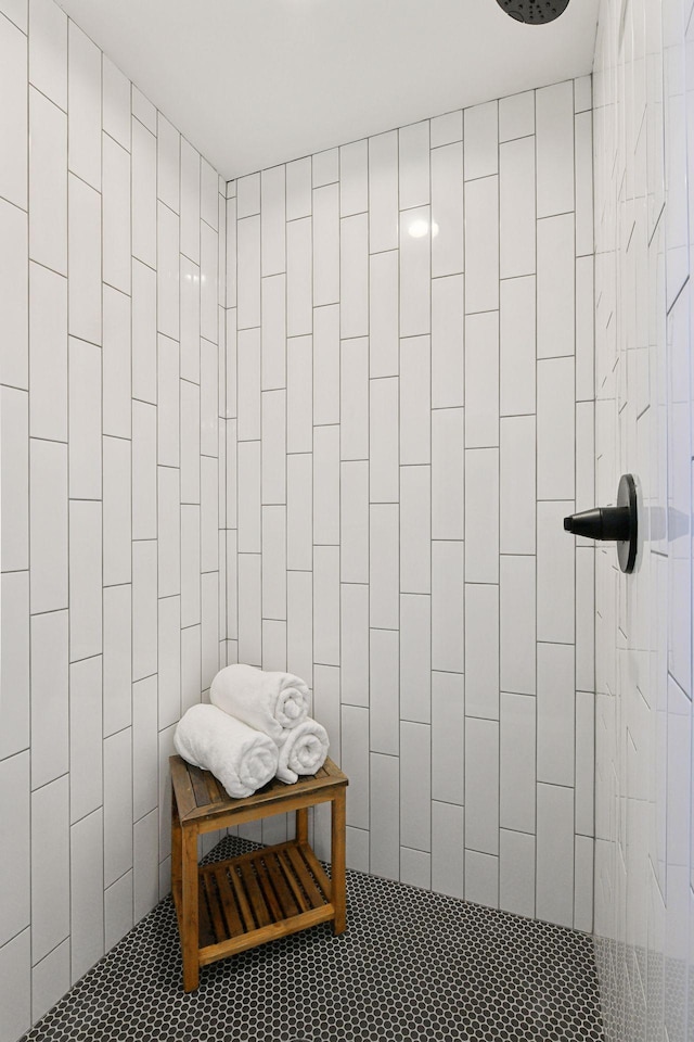 bathroom featuring tiled shower and tile walls