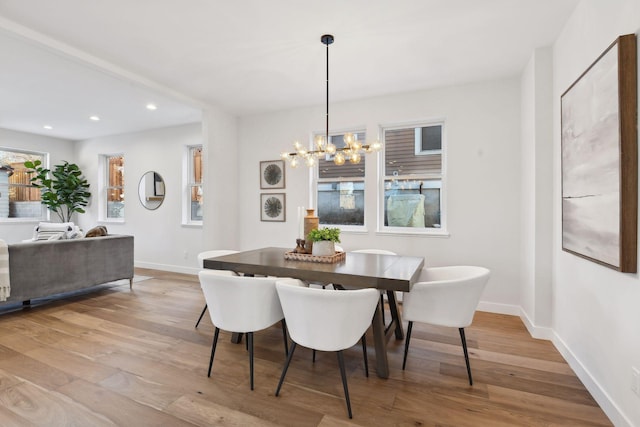 dining space featuring light hardwood / wood-style floors and an inviting chandelier