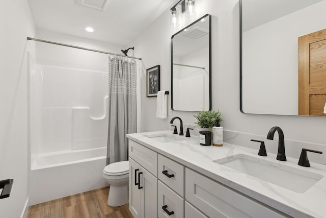 full bathroom with vanity, hardwood / wood-style floors, shower / bathtub combination with curtain, and toilet