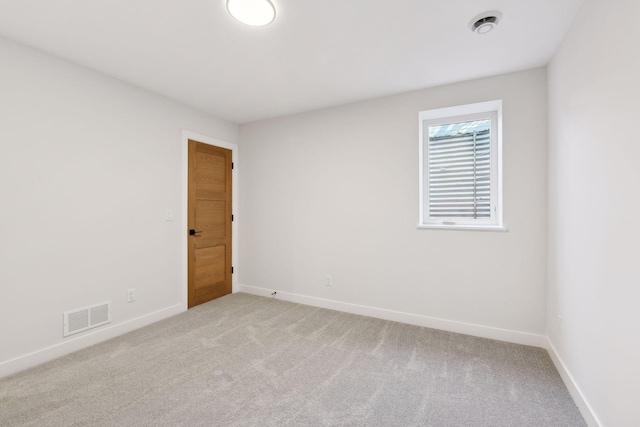 spare room featuring light colored carpet