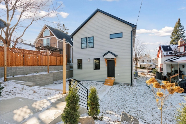 snow covered property with central air condition unit