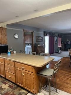 kitchen with independent washer and dryer and a breakfast bar area