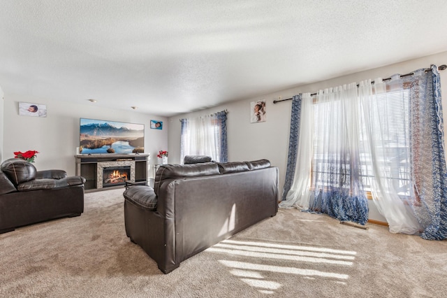 living room featuring a stone fireplace, a textured ceiling, and carpet