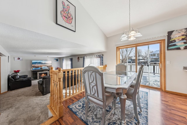 dining room featuring high vaulted ceiling, hardwood / wood-style floors, and a chandelier