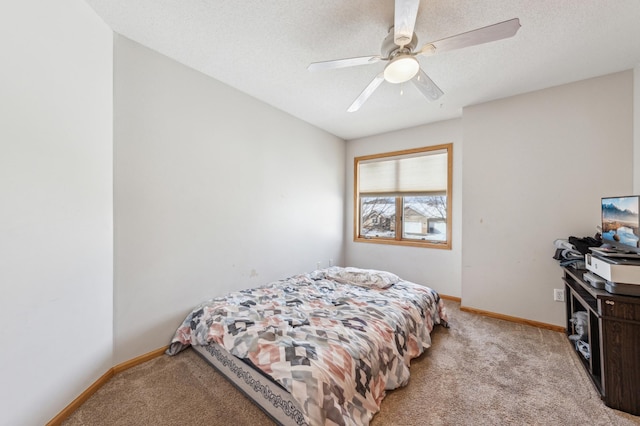 bedroom with ceiling fan, light colored carpet, and a textured ceiling