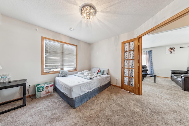 bedroom featuring a notable chandelier, a textured ceiling, and carpet flooring