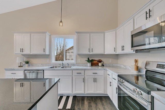 kitchen with sink, stainless steel appliances, dark hardwood / wood-style floors, vaulted ceiling, and white cabinets