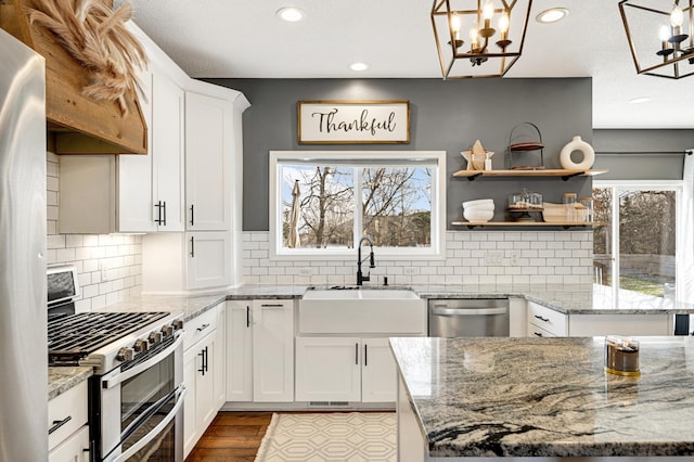 kitchen featuring pendant lighting, white cabinetry, sink, and stainless steel appliances