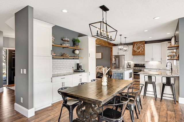 dining area featuring a textured ceiling, dark hardwood / wood-style floors, and sink