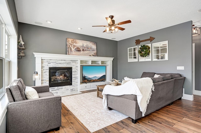 living room featuring a fireplace, ceiling fan, and hardwood / wood-style floors