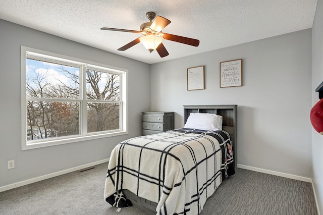 carpeted bedroom featuring ceiling fan and a textured ceiling