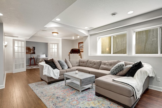 living room with a textured ceiling and dark hardwood / wood-style floors