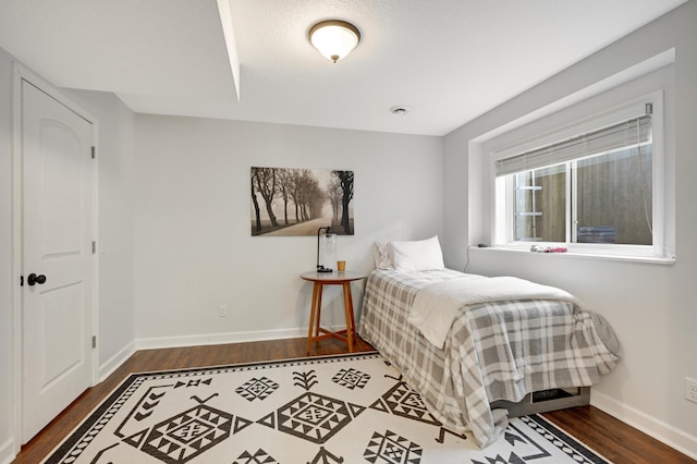 bedroom with dark hardwood / wood-style flooring