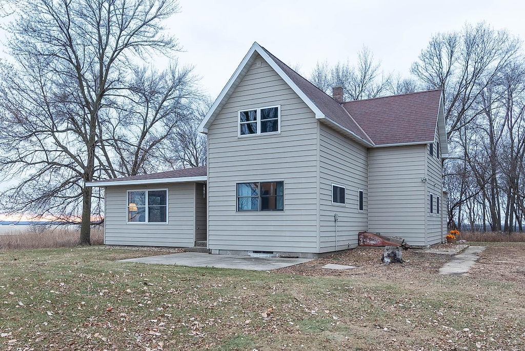 back of house with a lawn and a patio area