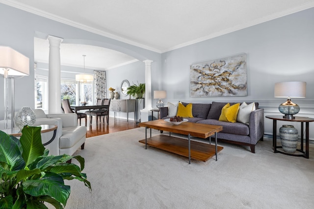 living room featuring ornate columns, arched walkways, and crown molding