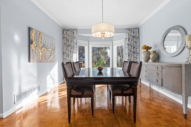 dining space featuring baseboards, visible vents, and crown molding