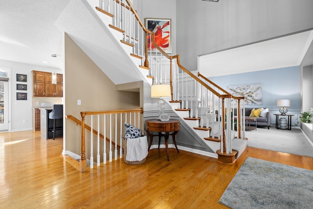 staircase with baseboards and wood finished floors