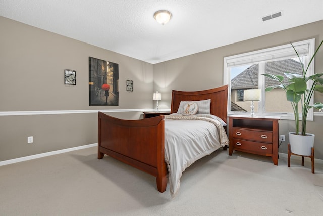 bedroom with light carpet, visible vents, baseboards, and a textured ceiling