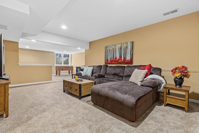 living area featuring visible vents, light carpet, and baseboards