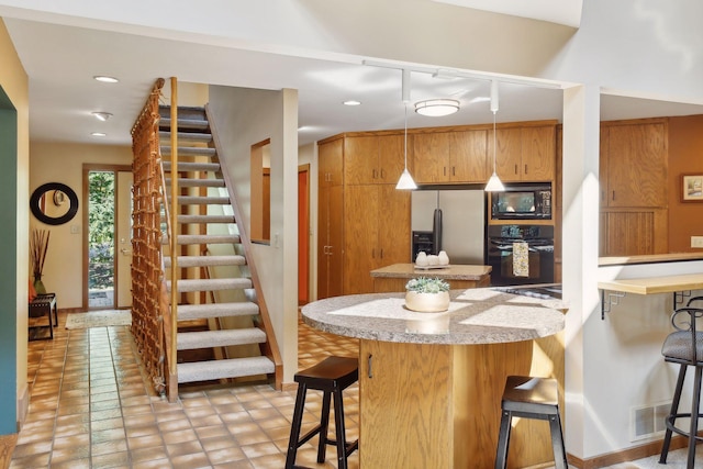 kitchen with a kitchen bar, kitchen peninsula, light tile patterned flooring, and black appliances