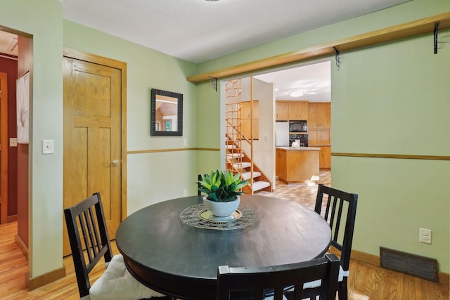 dining space with light wood-type flooring