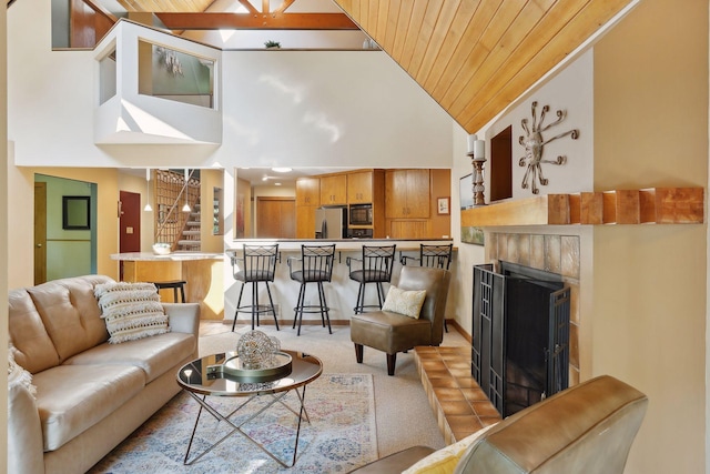 living room with a fireplace, high vaulted ceiling, and wood ceiling