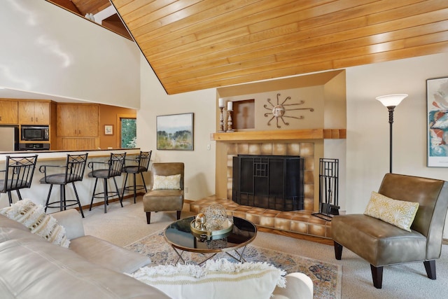 carpeted living room with a tile fireplace, high vaulted ceiling, and wood ceiling