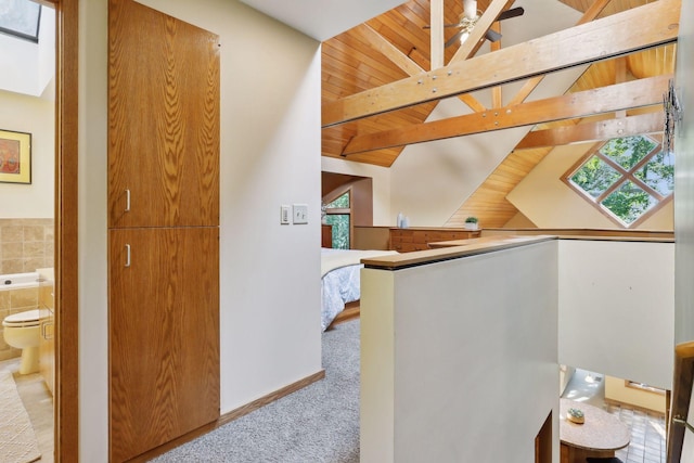 corridor with vaulted ceiling with beams, wood ceiling, and light carpet