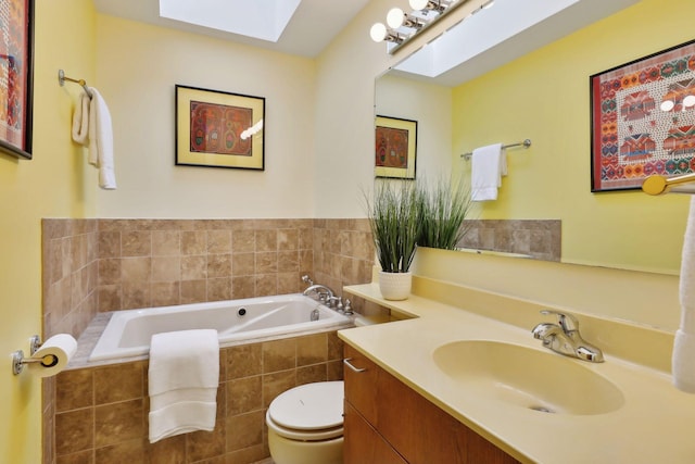 bathroom featuring vanity, a skylight, toilet, and tiled tub