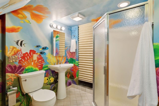 bathroom featuring tile patterned floors, toilet, and a shower with shower door