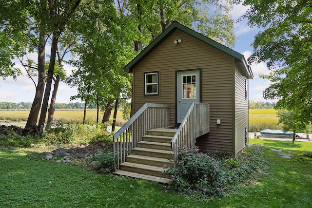 rear view of property with a rural view and a lawn