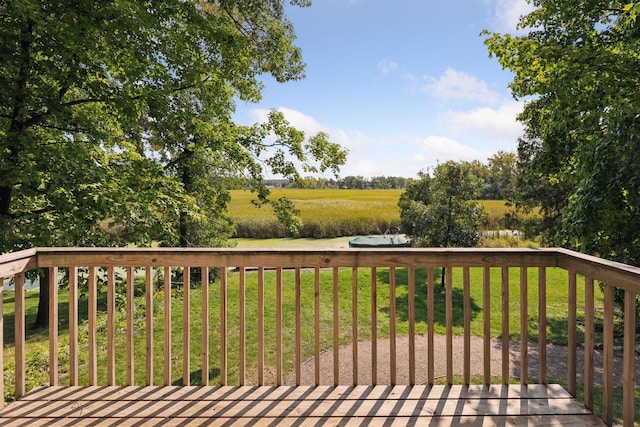 wooden deck featuring a yard and a rural view