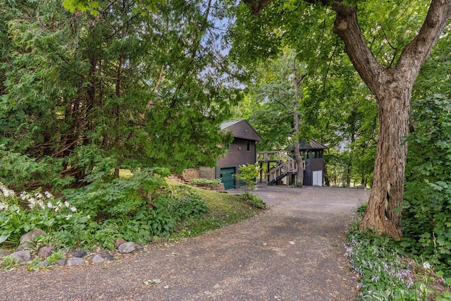 view of property hidden behind natural elements featuring a garage