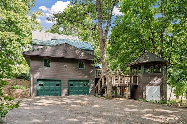 back of property featuring a garage and a wooden deck